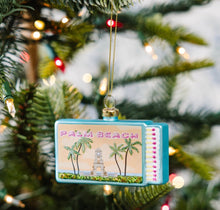 Load image into Gallery viewer, Decorative Palm Beach matchbox Christmas ornament with palm trees and clock tower scene