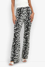 Load image into Gallery viewer, Wide-leg flare pants featuring a bold leopard print pattern, styled with heels