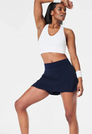 Spanx Get Moving navy skort with white crop top and wristband on model