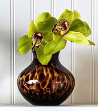 Load image into Gallery viewer, Juliska tortoiseshell patterned glass vase holding two elegant green cymbidium orchid blooms