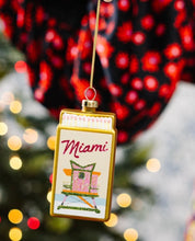 Load image into Gallery viewer, Decorative Miami-themed matchbox Christmas ornament featuring a lifeguard stand and gold trim