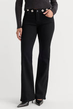 Load image into Gallery viewer, Good American flared jeans featuring floral jewel embellishments along the waistband, styled with heels