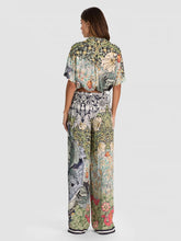 Load image into Gallery viewer, Woman wearing wide-leg floral botanical print pants with matching cropped shirt, back view