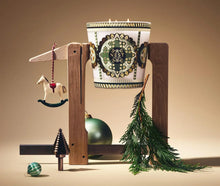 Load image into Gallery viewer, Nest x Pierre Marie Birchwood Pine 3-Wick Candle displayed with festive holiday decorations and greenery