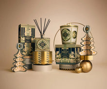 Load image into Gallery viewer, Nest x Pierre Marie Birchwood Pine 3-Wick Candle displayed with festive holiday gift set collection