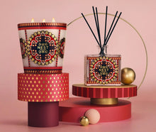Load image into Gallery viewer, Nest New York holiday three-wick candle and reed diffuser with ornate festive patterned packaging displayed elegantly
