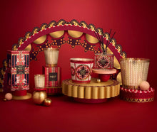 Load image into Gallery viewer, Nest x Pierre Marie Holiday 3-Wick Candle displayed in a festive, ornate holiday arrangement with matching collection pieces