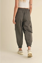 Load image into Gallery viewer, Woman wearing relaxed fit cargo jogger pants with elastic waistband and ankle cuffs