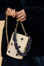 Load image into Gallery viewer, Cream leather bucket bag with navy chain handles and gold eyelet details