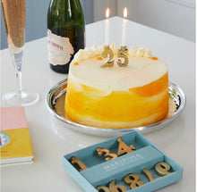 Load image into Gallery viewer, Mariposa gold number candle holders displayed on a celebration cake with champagne nearby