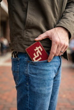 Load image into Gallery viewer, Man placing an FSU needlepoint card wallet into his back jeans pocket