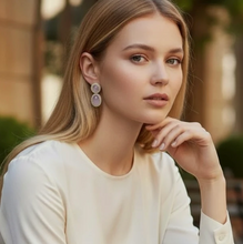 Load image into Gallery viewer, Model wearing elegant oval jade drop earrings with diamond halo setting, showcasing delicate craftsmanship