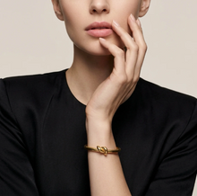 Load image into Gallery viewer, Model wearing Tat2 Noa Knot Bangle on wrist with hand raised to chin