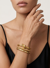 Load image into Gallery viewer, Model wearing stacked gold Noa Knot Bangle with twisted and smooth band details