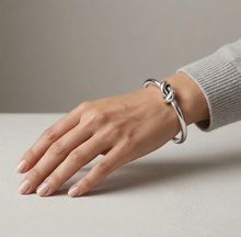 Load image into Gallery viewer, Tat2 Vintage Silver Noa Knot Bangle worn on a model's wrist, featuring an elegant knotted detail.