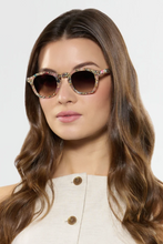 Load image into Gallery viewer, Krewe Dylan sunglasses with floral acetate frames and brown gradient lenses on model
