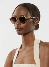Load image into Gallery viewer, Model wearing Krewe Dakota polarized round tortoise sunglasses with 18K accents, elegant profile view
