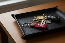 Load image into Gallery viewer, A crimson and white embroidered keychain featuring the Alabama Crimson Tide 'A' logo, with a brown leather tab stamped 'S&amp;B' and attached to two silver metal key rings.
