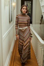Load image into Gallery viewer, Model wearing a long chevron knit skirt with matching turtleneck top and white belt