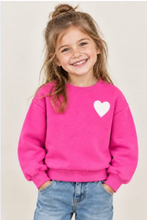 Load image into Gallery viewer, Young girl smiling and wearing a cozy heart graphic crewneck sweatshirt with jeans