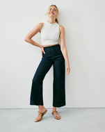 Women's dark indigo high-rise crop wide leg jeans with white sleeveless top and gold sandals