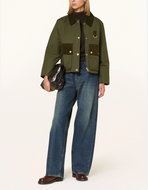 Woman wearing a cropped Barbour Phoebe jacket with corduroy trim, paired with wide-leg jeans