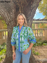 Load image into Gallery viewer, Woman wearing a vibrant ikat-printed top with three-quarter sleeves and decorative neckline trim