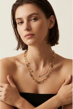 Load image into Gallery viewer, Model wearing layered chain necklace with crystal accents and mixed metal detailing
