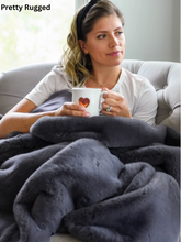 Load image into Gallery viewer, Woman relaxing on sofa wrapped in a luxurious Pretty Rugged faux fur blanket holding a mug