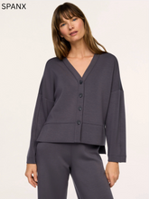 Load image into Gallery viewer, Woman wearing a relaxed-fit button-front V-neck cardigan with long sleeves and front pockets
