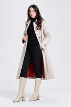 Load image into Gallery viewer, Woman wearing a classic belted trench coat with red lining, styled over black turtleneck and pants