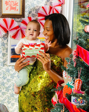 Load image into Gallery viewer, Smiling woman holding baby and Santa Baby Mini Pillow near decorated Christmas tree