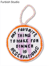 Load image into Gallery viewer, Circular needlepoint ornament reading 'My Favorite Thing To Make For Dinner Is Reservations'