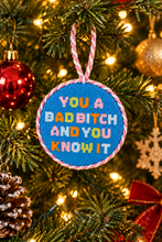 Load image into Gallery viewer, Needlepoint Christmas ornament with bold embroidered text hanging on decorated holiday tree