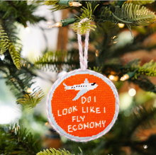 Load image into Gallery viewer, Needlepoint Christmas ornament with airplane graphic reading 'Do I Look Like I Fly Economy'