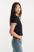 Load image into Gallery viewer, Woman wearing a cropped layered T-shirt with contrast trim, paired with relaxed denim jeans