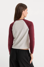Load image into Gallery viewer, Woman wearing a two-tone long sleeve raglan crop tee, back view