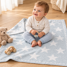 Load image into Gallery viewer, Smiling baby sitting on a soft star-patterned Barefoot Dreams receiving blanket with toys nearby