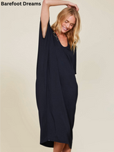 Load image into Gallery viewer, Woman wearing a relaxed, flowing long caftan dress with short sleeves and V-neckline