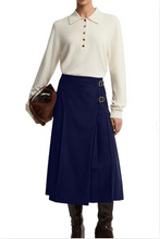 Load image into Gallery viewer, Barbour Delilah midi pleated skirt with gold buckle detail, styled with knit polo top and boots