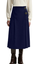 Load image into Gallery viewer, Barbour Delilah pleated midi skirt with gold buckle details, styled with knee-high boots