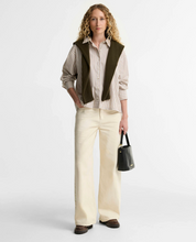 Load image into Gallery viewer, Woman wearing a striped button-up shirt layered under a knit vest with wide-leg trousers