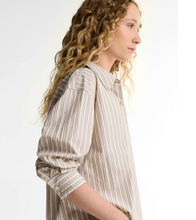 Load image into Gallery viewer, Woman wearing a relaxed striped long-sleeve button-up shirt with collar and cuffed sleeves