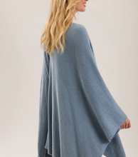 Load image into Gallery viewer, Woman wearing a flowing, oversized knit wrap with wide sleeves and relaxed silhouette