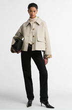 Load image into Gallery viewer, Woman wearing a cropped button-front showerproof jacket with plaid cuff lining and patch pockets