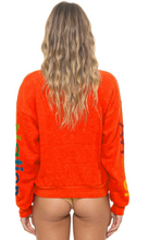 Load image into Gallery viewer, Woman wearing a relaxed fit crew neck sweatshirt with colorful sleeve lettering, back view