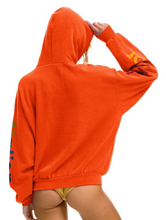 Load image into Gallery viewer, Woman wearing an oversized pullover hoodie with colorful logo graphics on sleeves