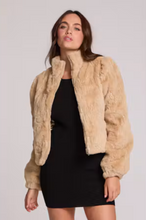 Load image into Gallery viewer, Women's cropped beige faux fur bomber jacket with puff sleeves worn over black mini dress