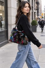 Load image into Gallery viewer, Woman walking city street carrying fluffy multicolored fox fur shoulder bag with leather strap