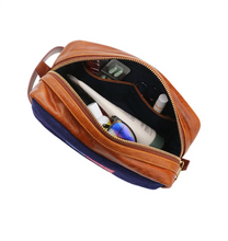 Load image into Gallery viewer, Open brown leather and navy canvas toiletry bag filled with grooming essentials